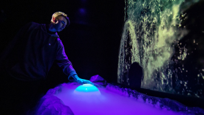 XYZ-Technologies_Parc-du-Bourg-de-Pabos_man approaching-a well-and-a-water-projection- on-the-wall