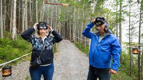 XYZ-Technologies_ParcDuBourgDePabos_Two adults wearing-AR headsets-observe a-floating-pipe -daytime-forest