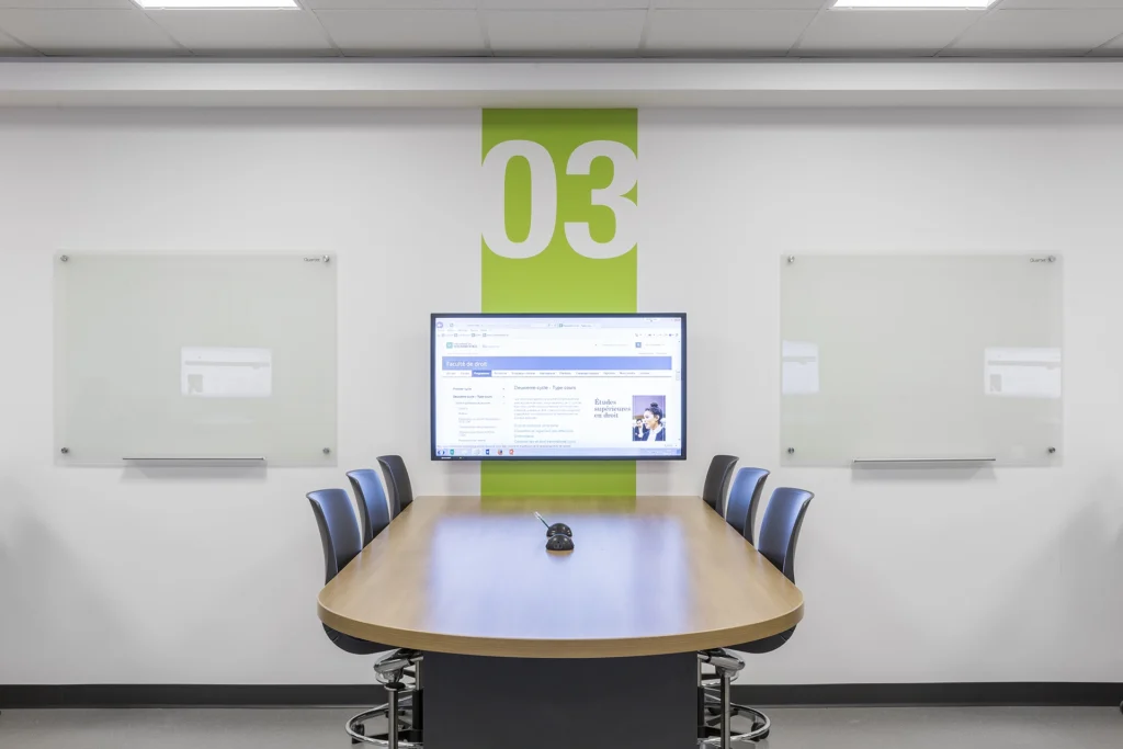 Aménagement collaboratif dans une salle de classe avec téléviseur.